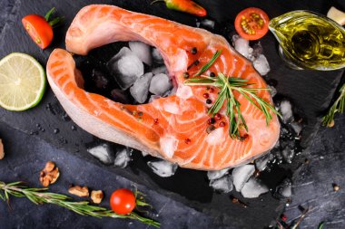 Büyük bir parça taze balık somonu, baharatlar, domates, limon, biberiye, yağ, yağ. Vücut için yararlı yiyecekler. Omega, düzgün beslenme.