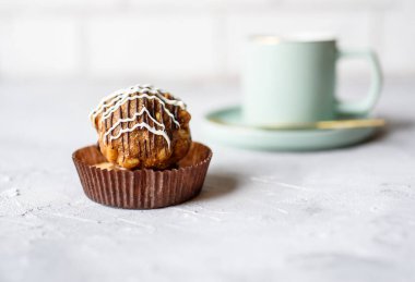 Güzel bir fincanda hafif bir tonda güzel kokulu çay. Kremalı lezzetli pasta ve kum hamuru. Beton zeminde tatlı ve çay.