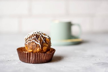 Güzel bir fincanda hafif bir tonda güzel kokulu çay. Kremalı lezzetli pasta ve kum hamuru. Beton zeminde tatlı ve çay.