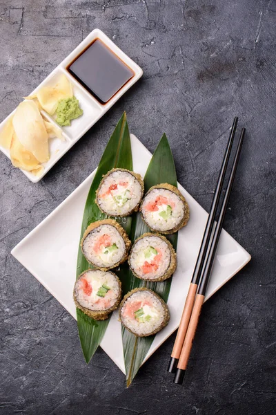 Avacado, somon, krem peynir, deniz yosunu, soya sosu ve zencefilli sandviç hazırla. Suşi yemeği.