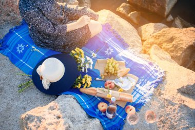 Şafakta deniz kenarında piknikte çiçekli bir kız. Romantik bir sabah. Yazın erken saatlerinde.