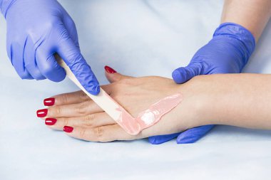 Güzellik salonunda kadın bacakları ve elleri inceleniyor. 