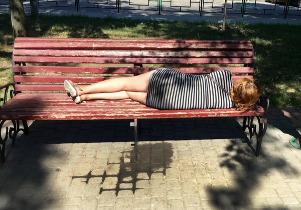 午前中に酔って 女の子は都市公園のベンチに横たわっています — ストック写真