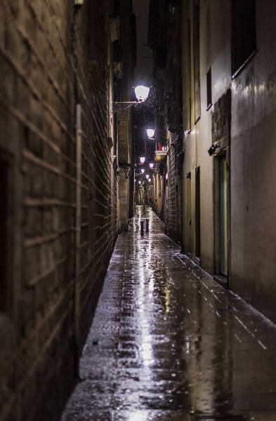 Night street in the gothic quarter of the city of Barcelona in Spain.