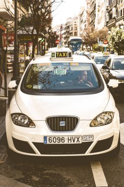 MADRID, SPAIN - 27 Mart 2018: Madrid şehrinin beyaz renkli taksisi şehir sokaklarında. 