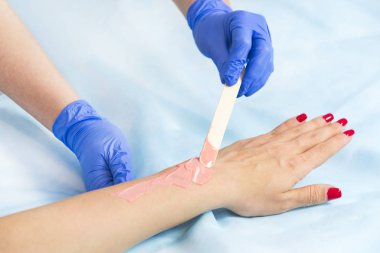 Güzellik salonunda kadın bacakları ve elleri inceleniyor. 