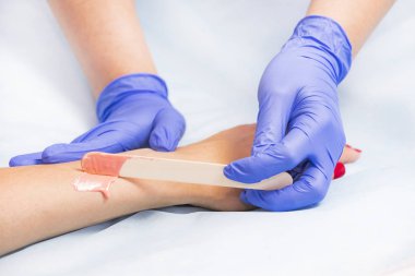 Güzellik salonunda kadın bacakları ve elleri inceleniyor. 