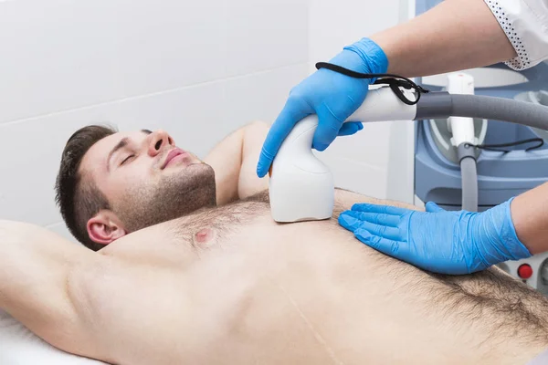 Man on the procedure of laser hair removal in the beauty salon