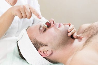 Adam bir modern tıbbi alet derma roller ile tıbbi mikro iğne tedavisinin yordamı geçer.