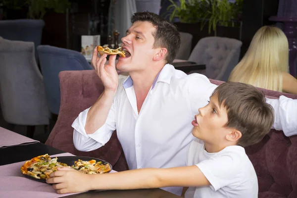 ピザ屋でイタリアのピザを食べて父息子 — ストック写真