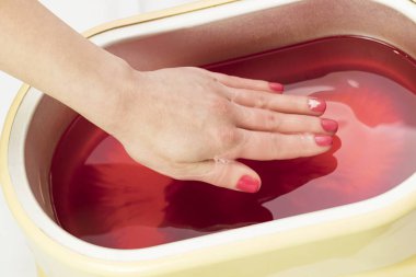 Güzellik salonunda kadın ellerine parafin tedavisi uygula 