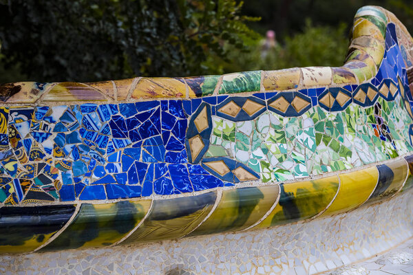 BARCELONA, SPAIN - 13 JANUARY 2018: Elements of mosaic fragments Gaudi's mosaic work in Park Guell In winter in the city of Barcelona. 