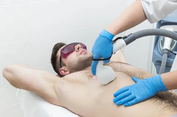 Man on the procedure of laser hair removal in the beauty salon