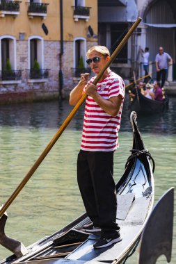 İtalya, Venedik - 5 Eylül 2018 Erkekler gondolcuları Venedik 'te turistlerle gondol sürerler.