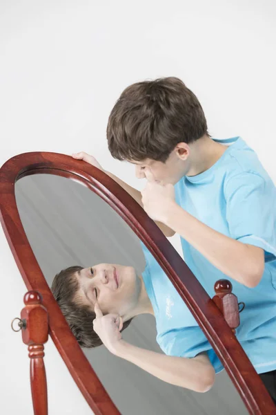 Ritratto Ragazzo Che Guarda Uno Specchio Uno Sfondo Bianco — Foto Stock