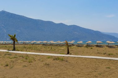 Issız kumsalı ile şemsiye ve şezlonglar 