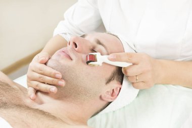 Yenilenme ve modern medikal enstrüman derisinin temizlenmesi prosedürü üzerine genç bir adam..