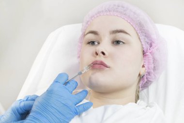 Klinikte genç bir kızın dudaklarının cerrahi düzeltme prosedürü