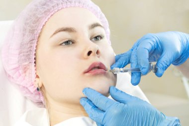 Klinikte genç bir kızın dudaklarının cerrahi düzeltme prosedürü