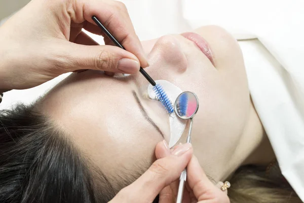 The procedure in the beauty salon eyelash extension and laminating woman.