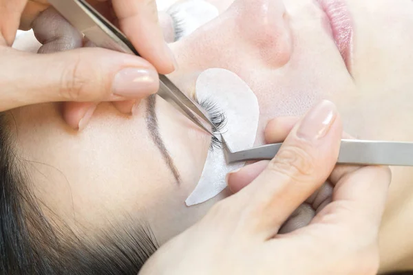 The procedure in the beauty salon eyelash extension and laminating woman.