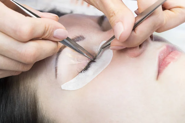 The procedure in the beauty salon eyelash extension and laminating woman.