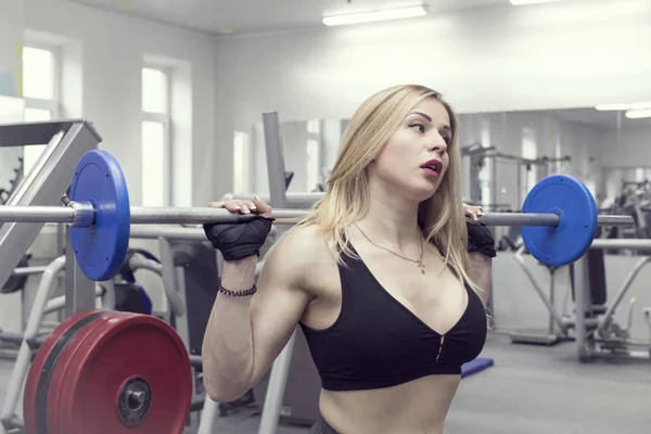 A girl in a gym with a shaker with a sports nutrition