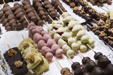 Meyve muz, çilek, fındık, elma, şeftali beyaz ve koyu çikolata sırılsıklam.