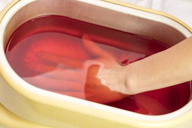 Güzellik salonunda kadın ellerine parafin tedavisi uygula 