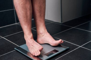 Adam tuvalette bir ölçekte ayakta