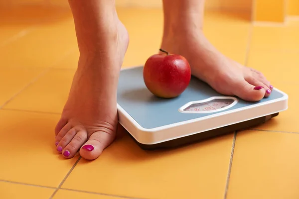 Paio Piedi Femminili Piedi Una Bilancia Bagno Con Mela Rossa — Foto Stock