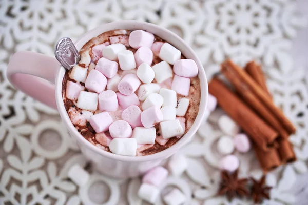 Pink mug of hot chocolate with marshmallows on table, top view