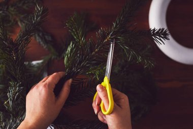 Çiçekçi kesme şube Noel çelenk dekorasyon için eller