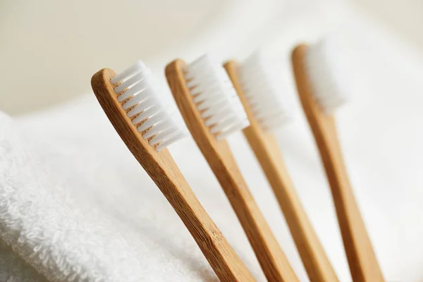 Four bamboo toothbrushes on white towel — Stock Photo, Image