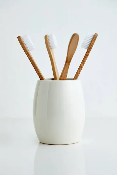 Four bamboo toothbrushes in gray glass — Stock Photo, Image