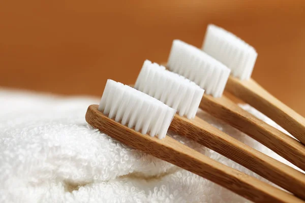 Four bamboo toothbrushes on white towel — Stock Photo, Image