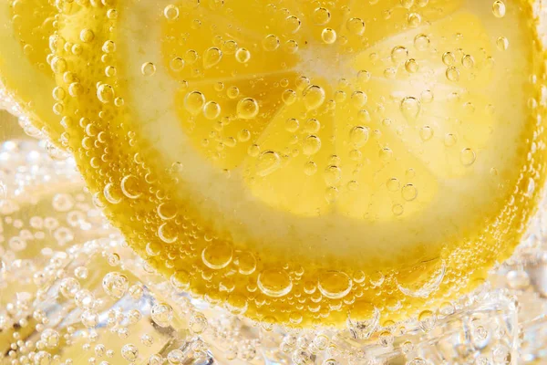 Limon dilimleri ve kabarcıklar ile su kapatın — Stok fotoğraf