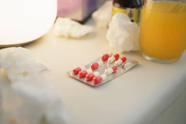 Comprimidos e antibióticos na mesa de cabeceira — Fotografia de Stock