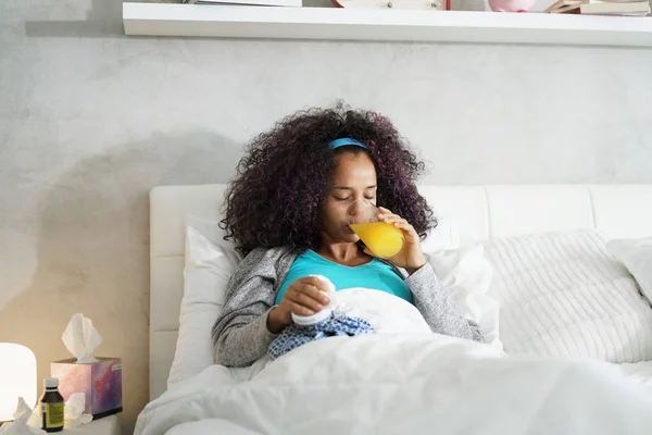 Mulher preta com gripe e frio segurando saco de gelo — Fotografia de Stock