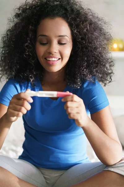 Mujer feliz sonriendo de alegría con kit de prueba de embarazo —  Fotos de Stock