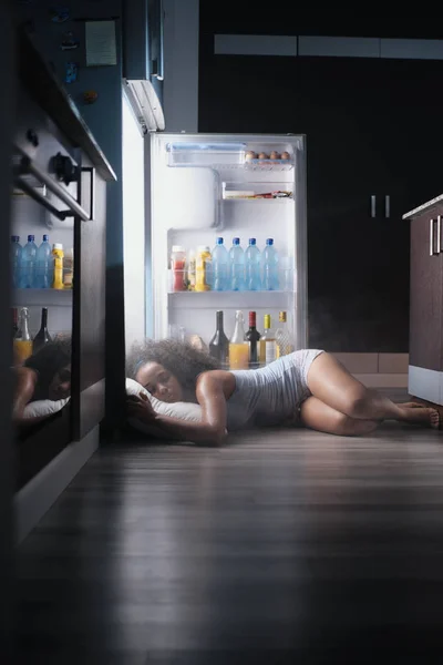 Zwarte vrouw wakker voor hittegolf slapen in koelkast — Stockfoto