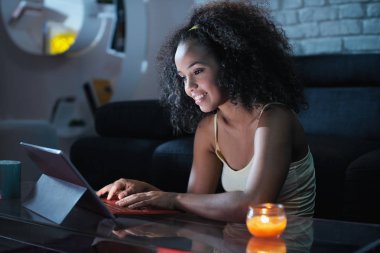 Young Latina Woman Typing Message on Laptop At Night clipart