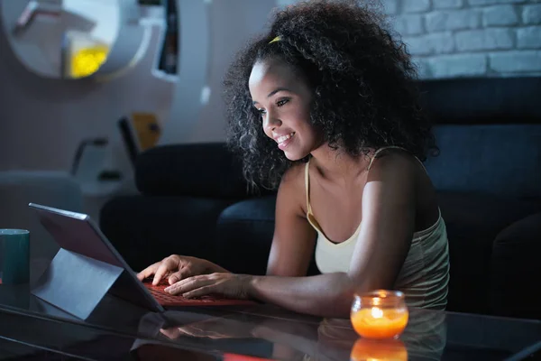 年轻拉丁妇女晚上在膝上型计算机上键入消息 — 图库照片