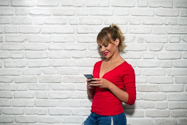 Gezichtsuitdrukkingen van jonge Blonde vrouw op bakstenen muur — Stockfoto