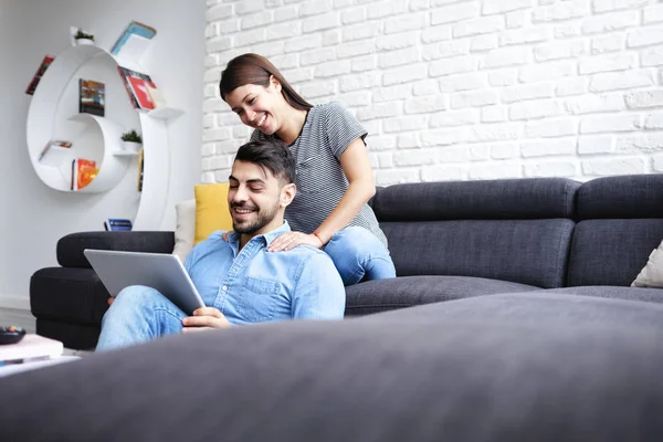 Girl Massaging Boyfriend On Sofa At Home — Stock Photo, Image