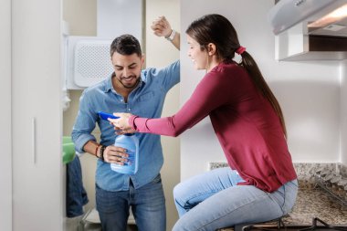 Genç çift temizlemenizi. Sosyal medya kullanımı ve resmi cep telefonu bakarak kadın ve erkek.