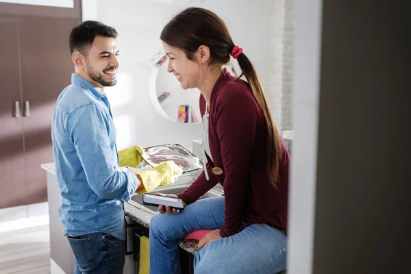 Mand og kvinde gør hjemmearbejde i køkkenet - Stock-foto