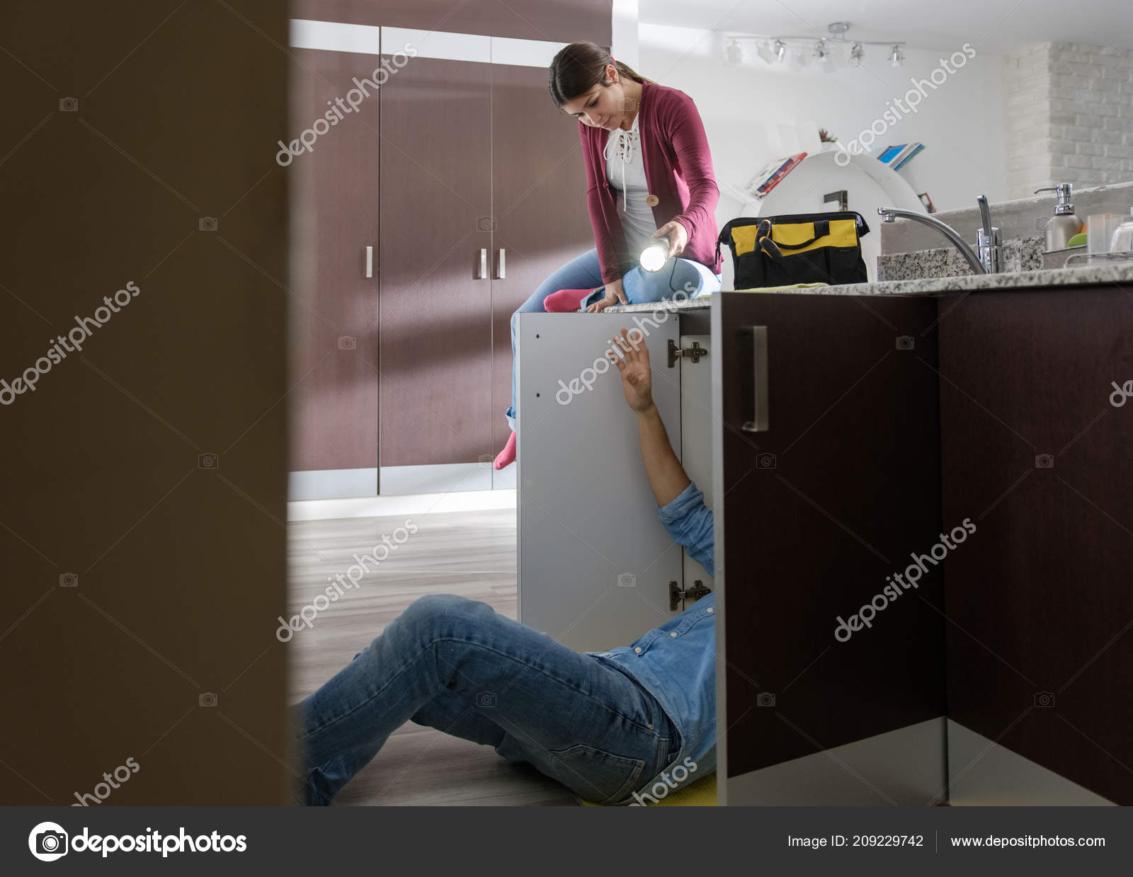 Handyman Husband And Wife Repairing Kitchen Sink Stock Photo
