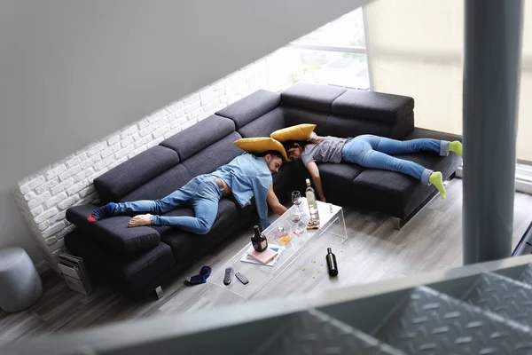 Berusad vänner sova på soffan i stökigt rum efter fest — Stockfoto