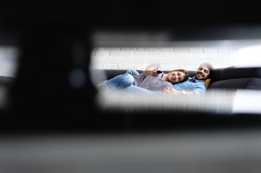 Genç çift TV izlerken kanepede sarılma